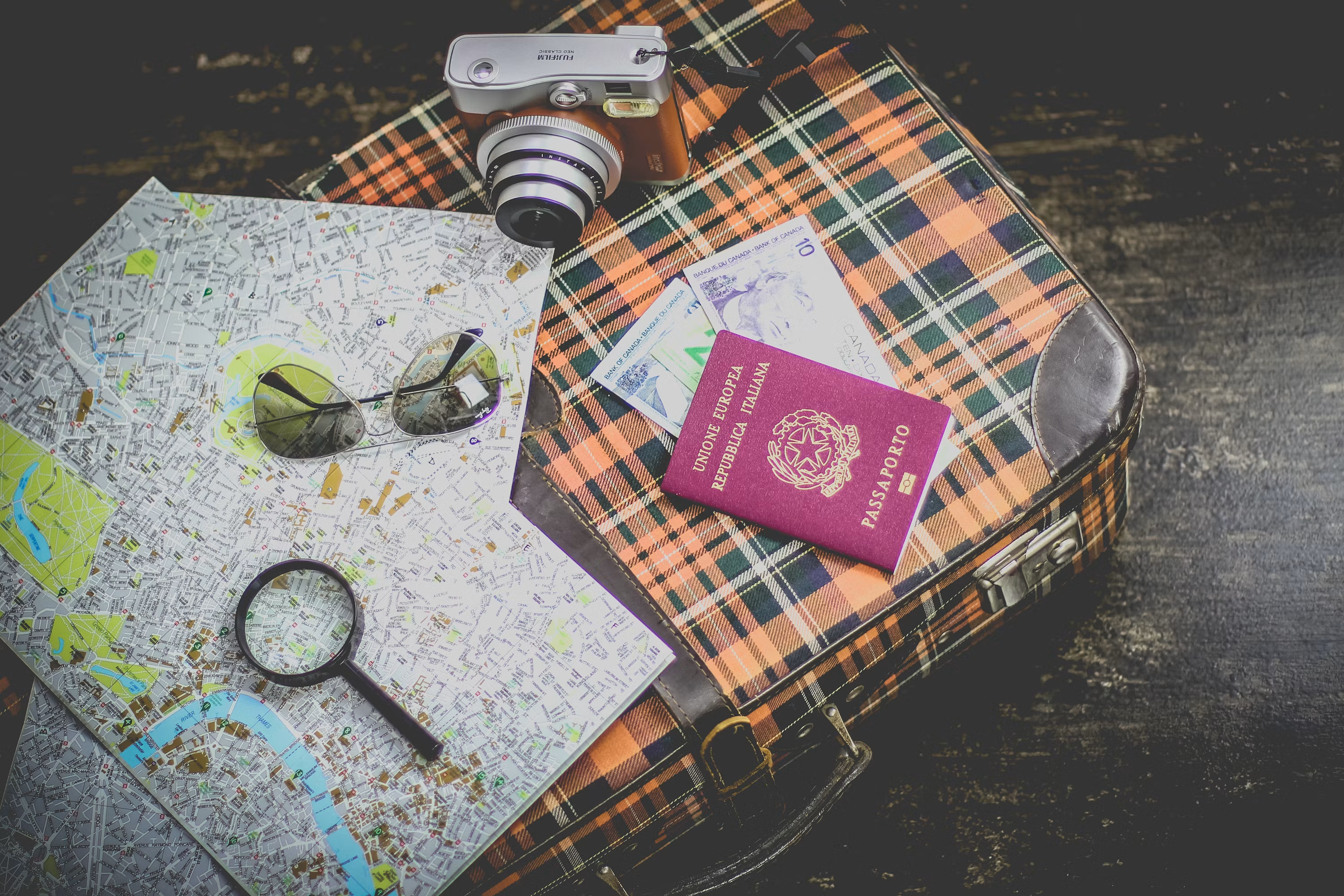 Passport, maps, and travel essentials laid out on a vintage suitcase
